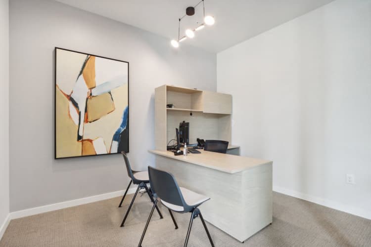 Milwaukee County apartments for rent - image - A modern office with a large abstract painting on the wall and a desk with two chairs