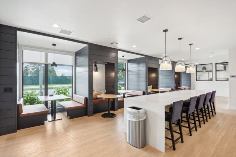 Milwaukee County apartments for rent - image - A modern kitchen with a long white island and black bar stools