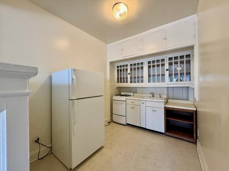 Milwaukee County apartments for rent - image - Charming vintage kitchen featuring classic white cabinetry, a spacious fridge, and cozy lighting.