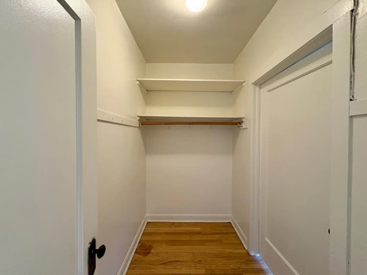 Milwaukee County apartments for rent - image - Spacious walk-in closet with built-in wooden shelving and elegant hardwood flooring.
