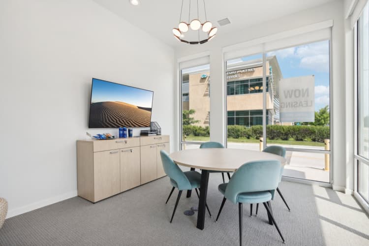 Milwaukee County apartments for rent - image - A conference room with a large screen on the cabinet and a table with four chairs