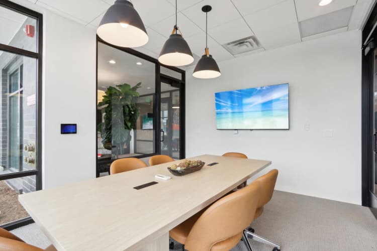 Milwaukee County apartments for rent - image - A conference room with a long table, chairs, and a television screen on the wall